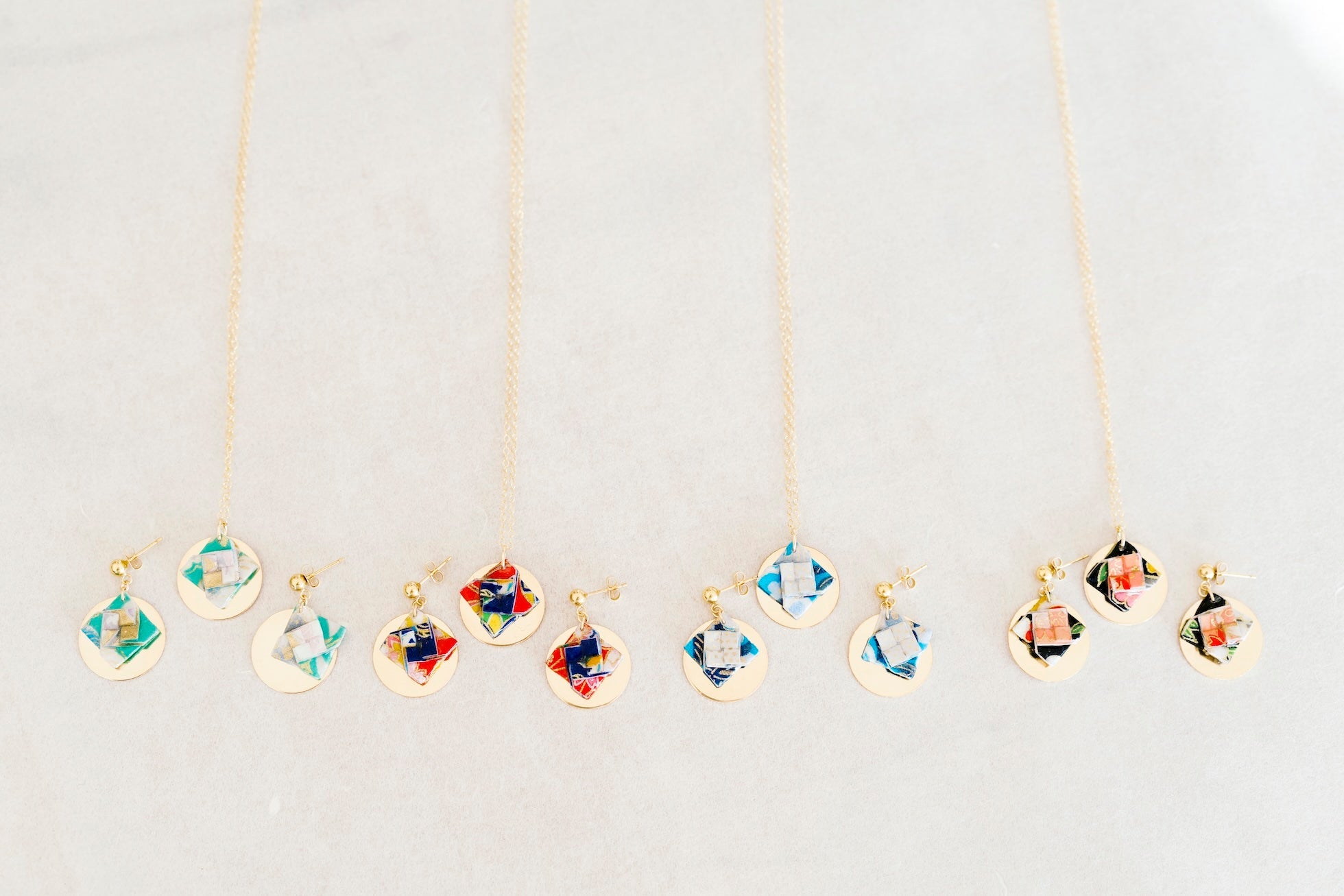 Handcrafted colorful origami necklaces on a neutral background