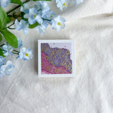 Purple floral design washi paper on a white fabric background with blue flowers.