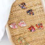 Colorful floral hoop earrings on a woven surface
