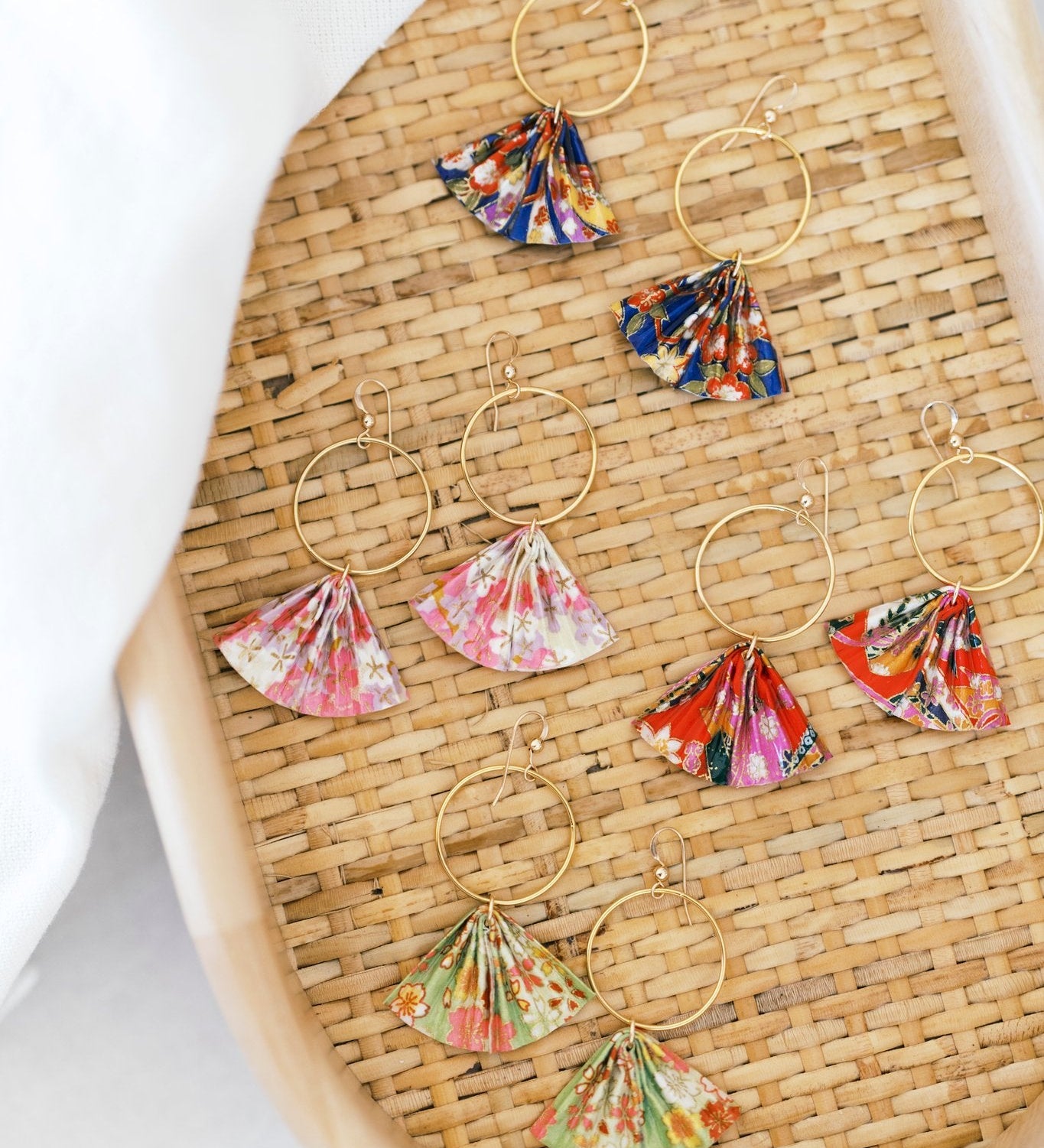 Colorful floral hoop earrings on a woven surface