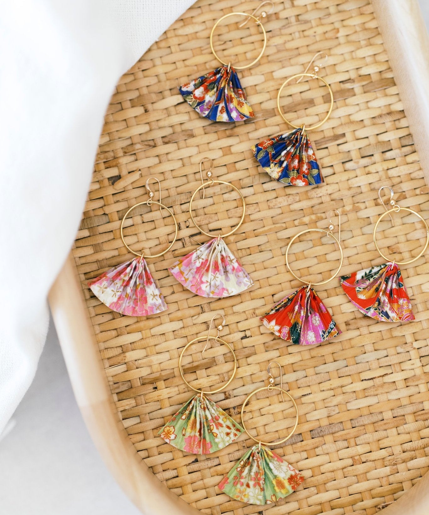 Colorful floral hoop earrings on a woven surface