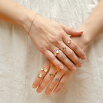 A person's hands displaying multiple rings with gold fill and washi paper patterns, arranged in a dome shape.