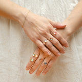 A person's hands displaying multiple rings with gold fill and washi paper patterns, arranged in a dome shape.