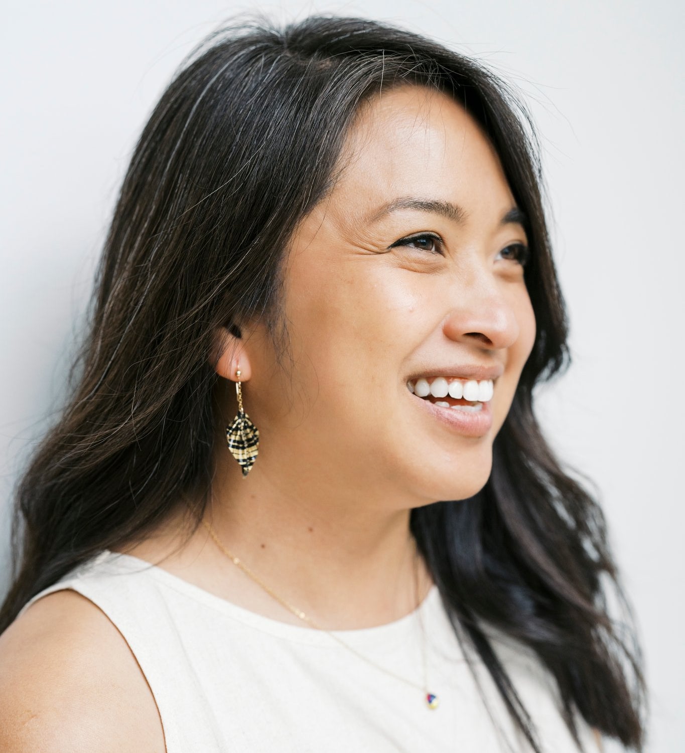 Model wearing origami leaf earrings against light background