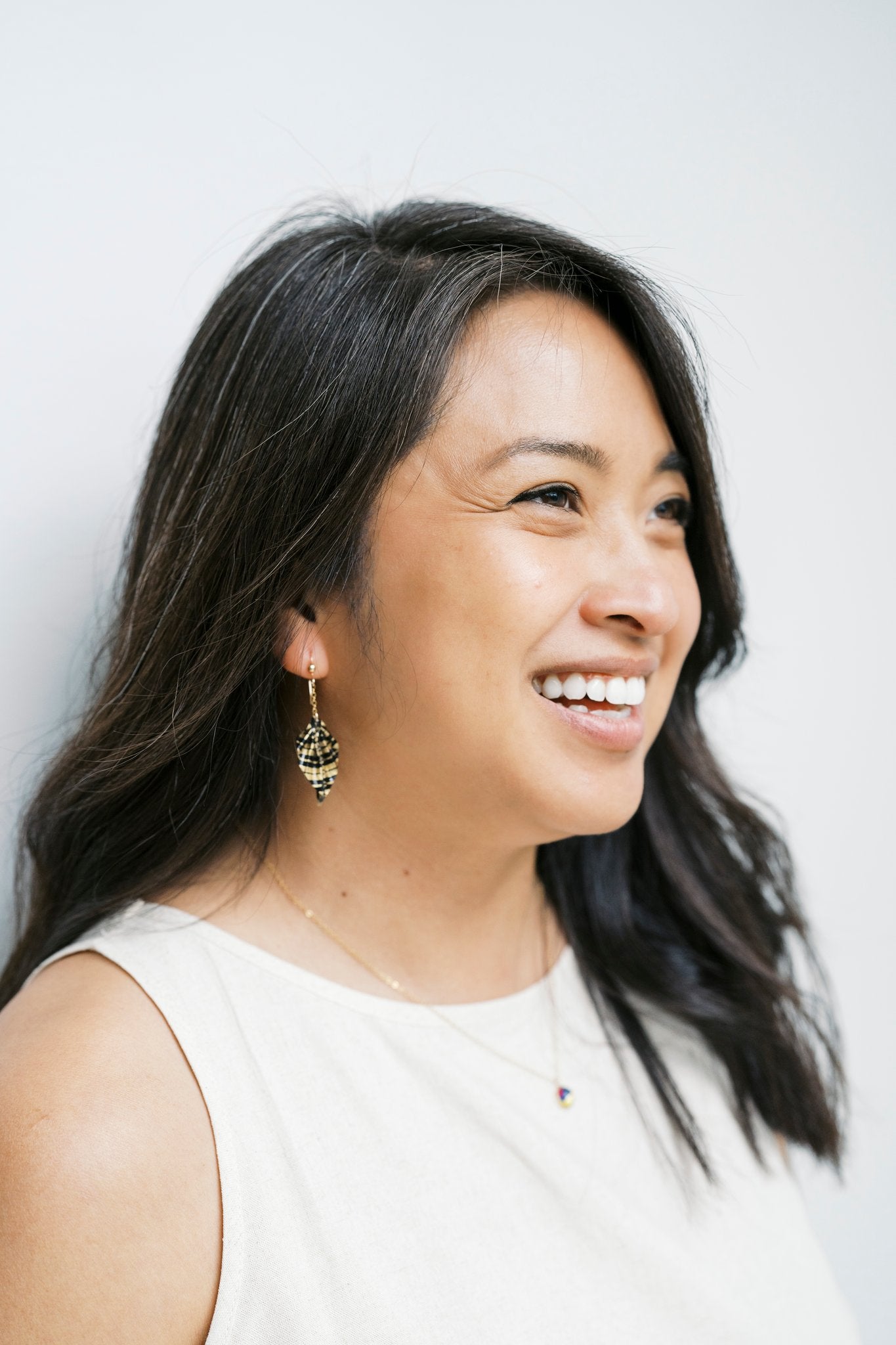 Model wearing origami leaf earrings against light background