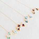 Colorful origami earring and necklace sets on grey fabric background