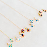 Colorful origami earring and necklace sets on grey fabric background