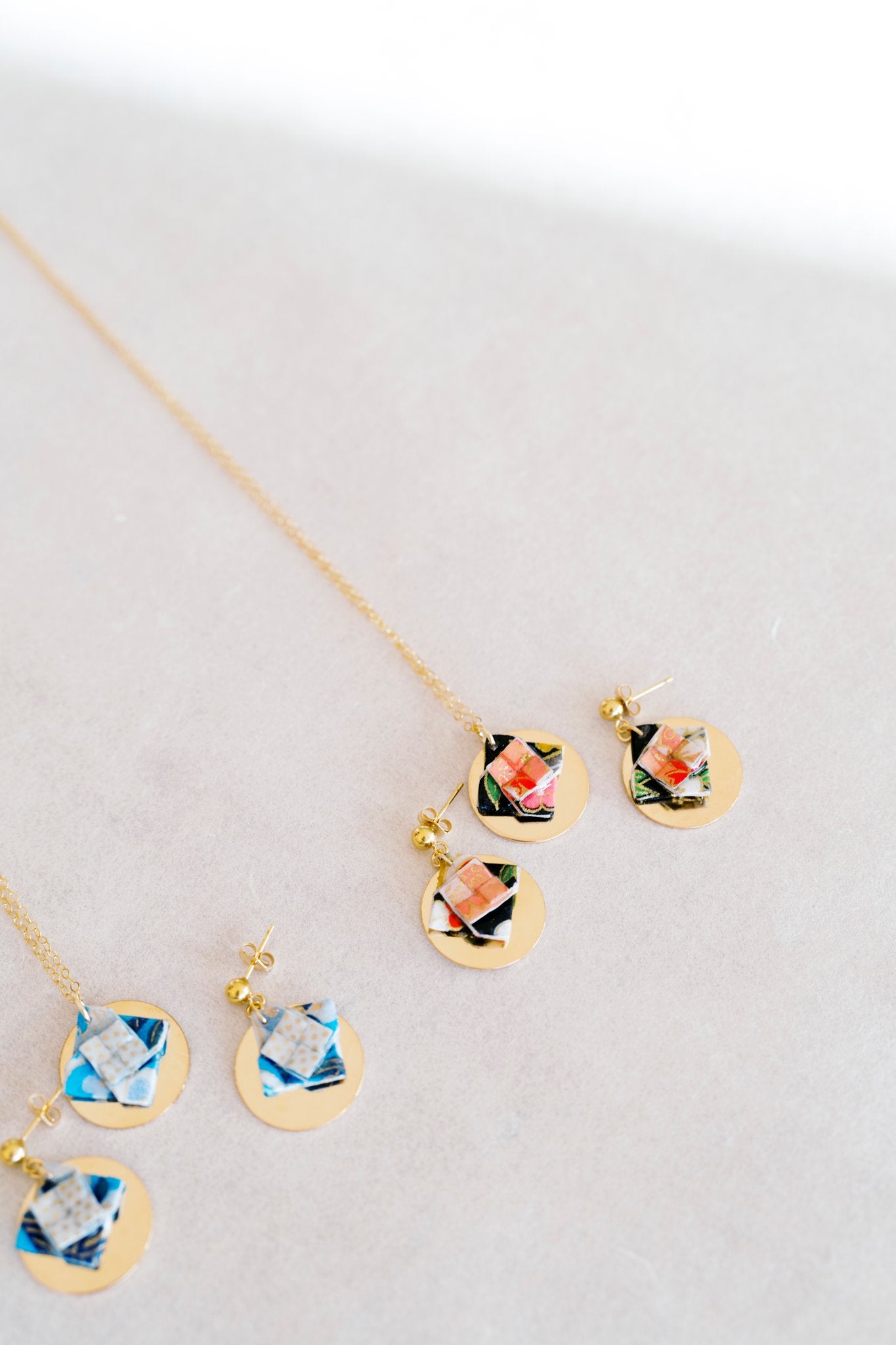 Jewelry set with floral designs and gold discon a light gray background
