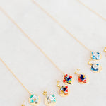 Jewelry set with floral designs and gold discon a light gray background