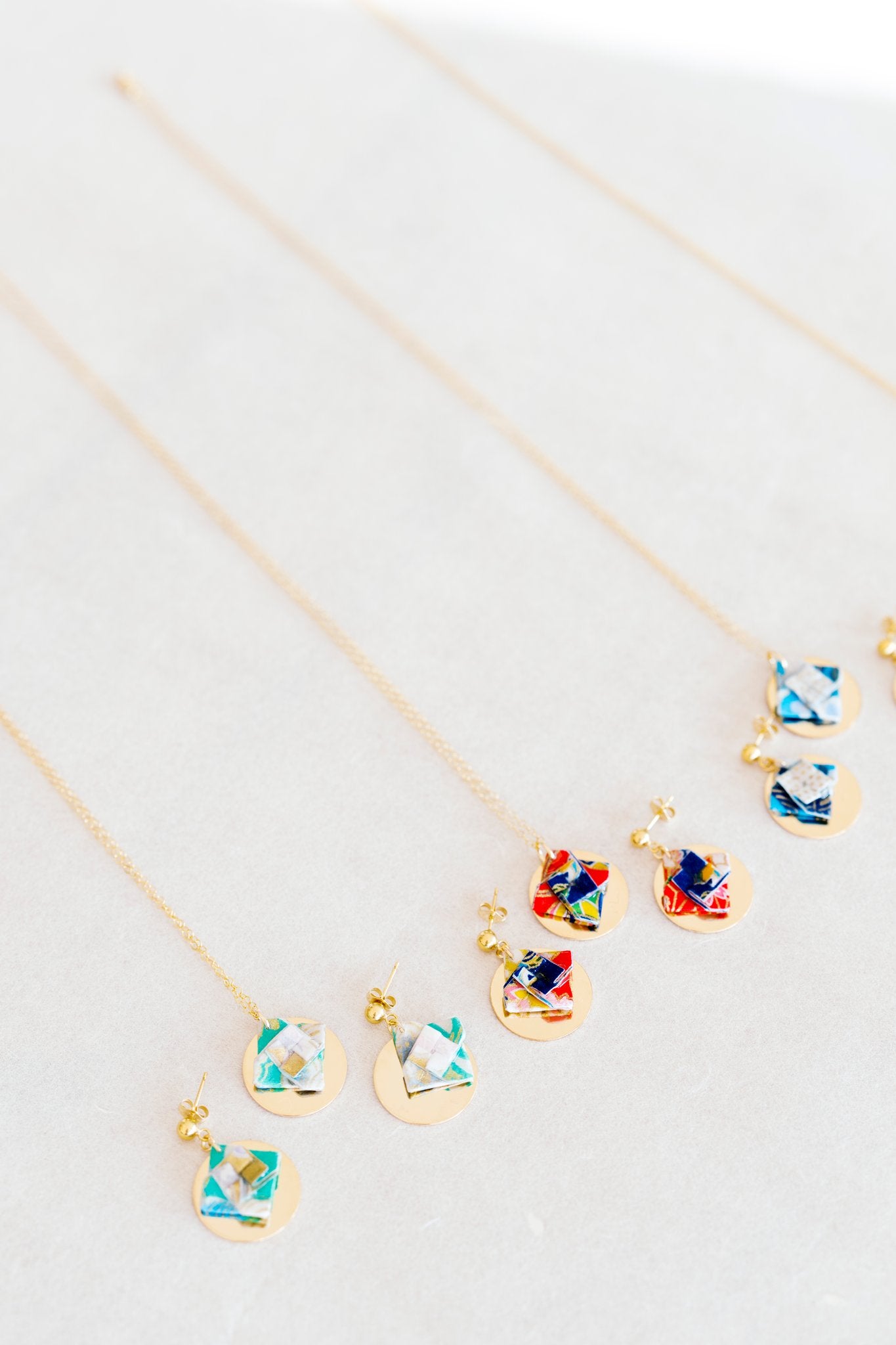 Jewelry set with floral designs and gold discon a light gray background