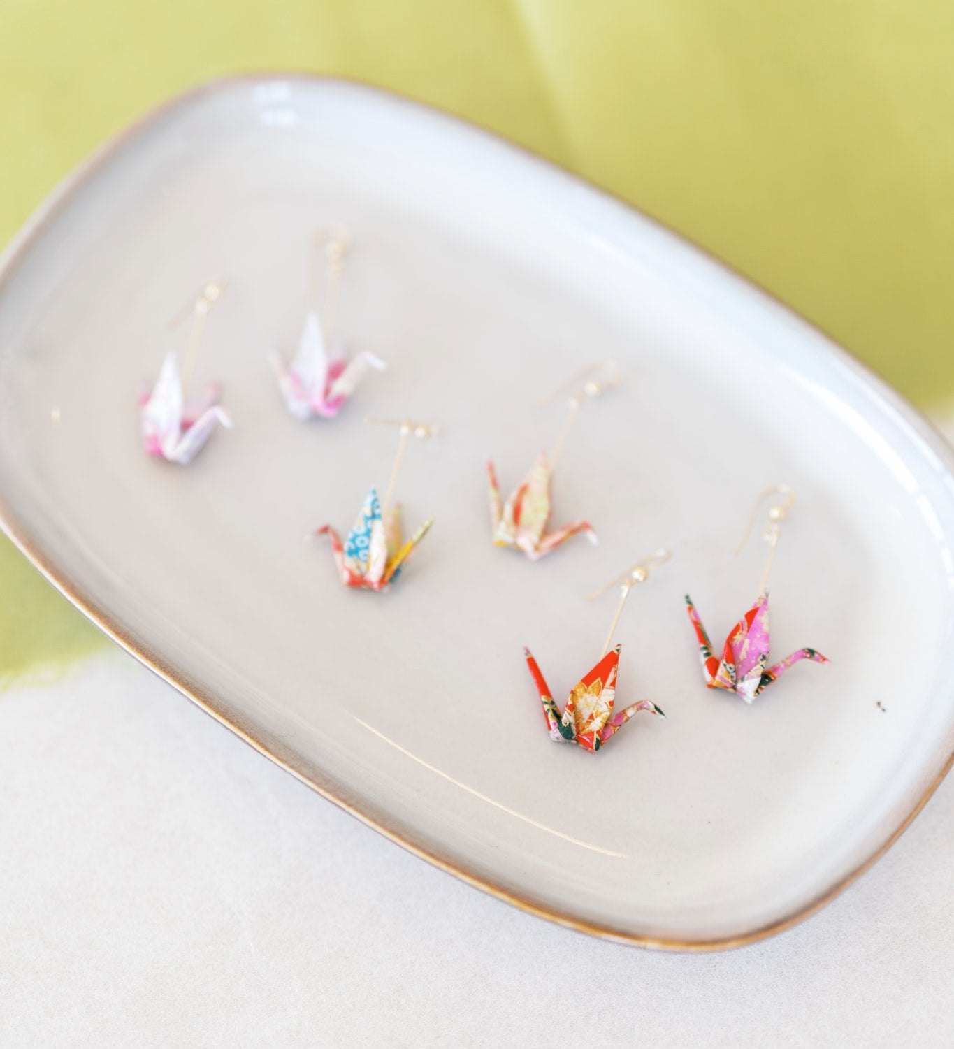 Origami crane earrings on a plate