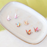Origami crane earrings on a plate