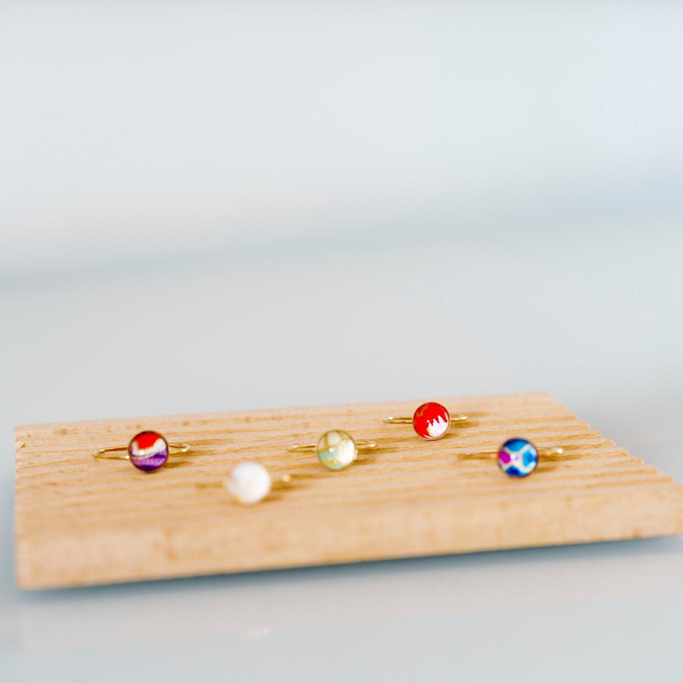 Set of colorful rings on a wooden board against a light gray background