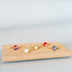 Set of colorful rings on a wooden board against a light gray background